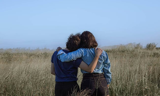 two woman holding each other