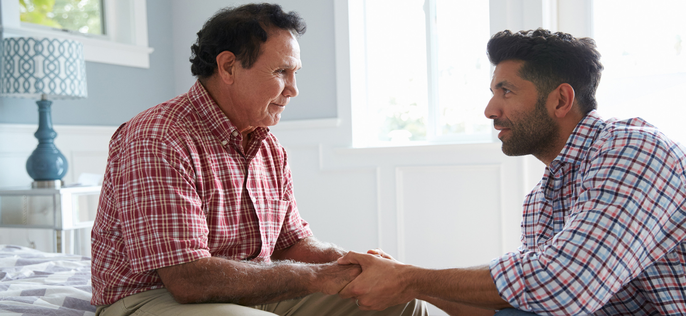 Adult Son Comforting Father Suffering With Dementia